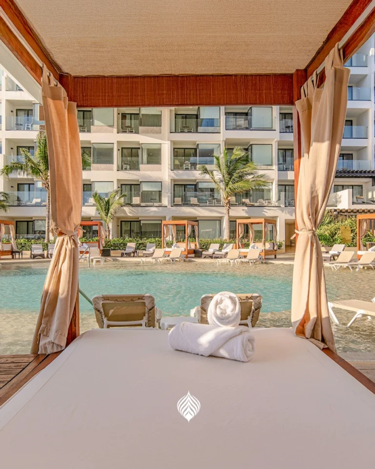 View from poolside cabana at tropical resort, with curtains and relaxing atmosphere.